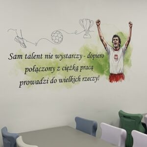 Druk ścienny UV z cytatem i ilustracją Włodzimierza Lubańskiego w świetlicy szkolnej Szkoły Podstawowej w Gaci
