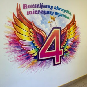 Kolorowy mural szkolny z liczbą 4, skrzydłami i napisem „Rozwijamy skrzydła, mierzymy wysoko!” wykonany technologią druku ściennego UV.