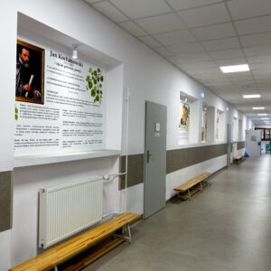 Korytarz Szkoły Podstawowej w Wądrożu Wielkim z tablicami edukacyjnymi na pleksi poświęconymi Janowi Kochanowskiemu