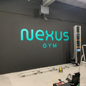 Logo Nexus Gym wykonane w technologii druku ściennego UV na ścianie siłowni we Wrocławiu.