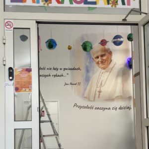 Ściana patrona z portretem Jana Pawła II wykonana drukiem ściennym UV w szkole we Wrocławiu